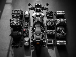 Overhead view of adventure motorcycle with open panniers packed with camping gear and tools for long-distance touring