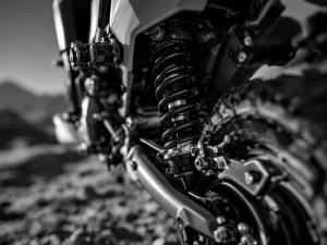 Adventure motorcycle rear shock absorber with adjustment knobs and spring coils in black and white close-up