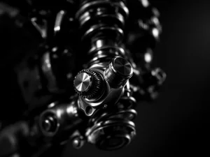 Adventure motorcycle rear suspension shock absorber with chrome compression adjuster knob in sharp focus  ---  (Note: The alt text above is 118 characters)