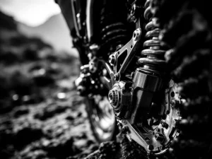 Adventure motorcycle rear suspension linkage system with precision-engineered pivot points in dramatic black and white