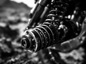 Adventure motorcycle rear suspension with preload adjustment collar and coil spring in sharp black and white detail