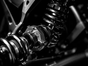 Adventure motorcycle rear suspension spring and shock absorber with preload adjuster in black and white close-up