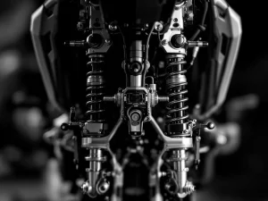 Adventure motorcycle rear suspension system with chrome shock absorber, manual adjustment knobs, and electronic sensors in black and white