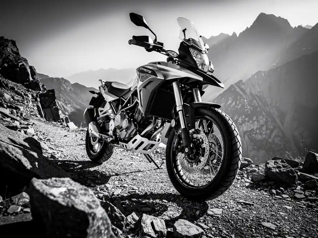 CFMOTO 450 MT adventure bike on a rocky mountain trail, suspension forks and rear shock absorber highlighted in dramatic monochrome contrast.