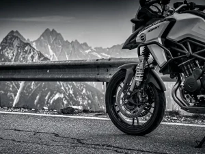 CFMOTO 450 MT adventure motorcycle parked on a mountain road, aftermarket rear shock absorber with coil spring and adjustment hardware in sharp focus.